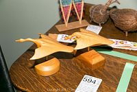 Photo showing a pair of wooden bird sculptures on bases, part of the lot's native art items