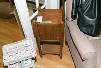 Wooden smokers cabinet showing front side with cupboard door, knob, turned legs, and a lower shelf.