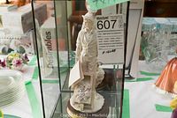 Front view of Leonardo figurine inside glass display case with label and surrounding items