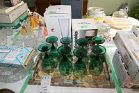 Photo 1 shows eight green smoked glass goblets arranged on a serving tray with additional glassware boxes around them.