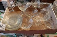 Top down view showing all dessert glasses with floral etching and stacked saucers in the box.