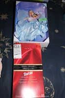 Photo showing Avon Winter Splendor Barbie doll in box with light blue satin dress and part of packaging visible.