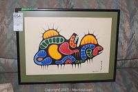 Full view of framed print showing abstract multicolored design, green mat and black frame