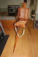 Full view of the wood folding art easel with case open and legs extended, showing the carrying strap and interior storage.