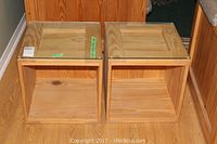 Two wood cube tables side by side showing glass tops and natural wood finish.