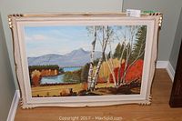 Framed oil on board landscape painting showing mountains, lake, and birch trees with autumn colors.