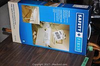 Boxed Safety First adjustable tub and shower stool in white plastic with metal legs.