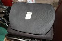 Top view of the wheelchair seat cushion showing textured black fabric and a label with number 690.