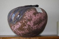 Side view of ceramic vase showing pink and brown textured finish with dark glossy drip design on top.