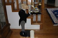 Full view of the "James the Butler" home decor piece holding a serving tray with a candle and decorative telephone on a hardwood floor near stairs.