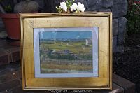Full view of the gilt framed print of Van Gogh's "Harvest" showing the frame and artwork together placed outdoors.