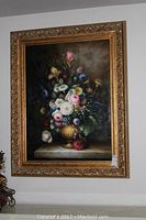Full view of framed floral oil painting hanging on wall