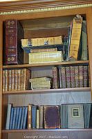 Full bookshelf overview showing all antique books across three shelves