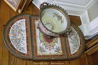 Top-down view of the three-piece ceramic plateau with floral and ornamental patterning and ornate decorative bowl on top.