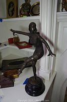 Full view of bronze dancer sculpture on round base