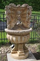 Full front view of entire fountain including back panel, basin, pedestal and base