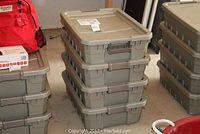Gray plastic storage containers stacked on the floor