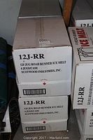 Three stacked cardboard cases labeled “12J-RR 12# Jug Road Runner Ice Melt, 4 Jugs/Case, Scotwood Industries, Inc.”