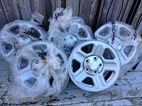 Five silver Jeep wheels stacked, one in front