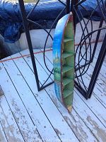 Side view of the painted wooden boat-shaped shelf showing the scenic artwork and shelf compartments.