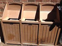 Full view of 3 compartment garbage/recycling unit made of recycled materials, showing earth-toned finish and individual doors.