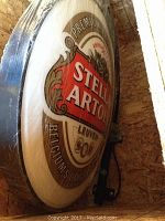Round Stella Artois sign in wooden crate, plastic wrapped