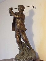Front view of golfer statue showing full body, stance, and attire details
