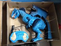 Blue dragon toy and wired remote control inside box.