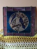 Front view of the stained glass panel showing the full square shape with purple border and blue jays in center circle.