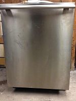 Front view of the stainless steel dishwasher showing scratches on the front panel and integrated handle at top.