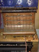 Front view showing copper heating element, protective wire grille, and base with Black & Decker label beneath heater.