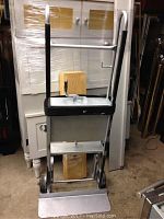 Front view of the heavy duty stairs furniture dolly showing tall metal frame, handle, base plate, and wheels.