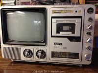 Front and left view of the vintage Pulsar 9-inch TV combined with AM/FM radio and cassette recorder showing overall layout and condition including volume control knob wear.