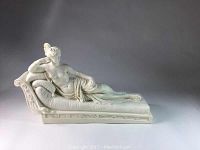 Side view of the white reclining figurine showing full body and chaise lounge base.