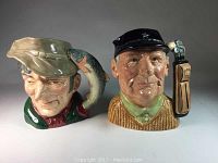 Front view of two ceramic Toby jugs showing detailed facial expressions and character features for The Golfer and The Poacher.
