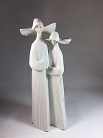 Front view of Lladro porcelain figurine showing two nuns with long robes and wide hats.