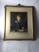 Full view of the framed mezzotint portrait The Little Midshipman showing the gold ornate frame with decorative top center and the portrait of a young boy in blue naval uniform jacket.