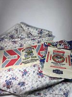Both vintage flour sacks laid on floral quilt showing front and side view