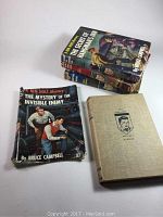 Four Ken Holt mystery books stacked and displayed, one showing front cover fully, one book cover without jacket visible.