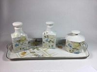 Front view of two Limoges hand-painted porcelain bottles and one covered jar on a Tirschenreuth porcelain tray with yellow rose floral design