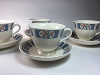 Set of four Wedgwood Kyoto pattern footed cups with matching deep saucers, showing blue and floral design.