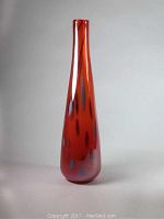 Front view of tall red art glass vase with steel gray spots showing full height and shape