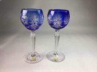 Pair of cobalt blue cut to clear Bohemian crystal wine glasses with detailed cut stems and bases, side view showing starburst design