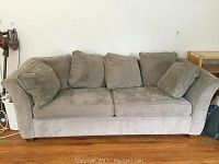 Front view of grey queen size sleeper sofa with cushions showing wear and stains.
