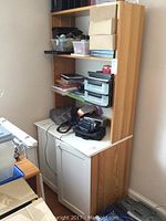 Full view of the breakfront bookcase with multiple shelves and a two-door cabinet base, showing wood-tone finish and items on shelves.