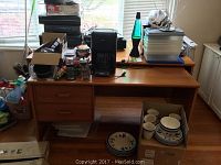 Photo of full desk with stacking drawers on the left, expandable work surface partially extended. Desk surface has various miscellaneous items on it.