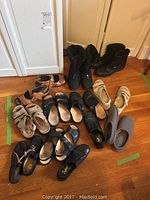 Overview of assortment including boots, sandals, slippers on hardwood floor