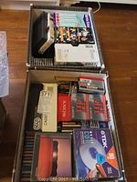 Top view of two boxes filled with audio cassettes, VHS tapes, and CDs.