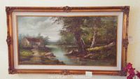 Full view of the framed landscape painting showing the river, cypress trees, cabin and overall setting