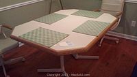 Top view of the rectangular dining table with a beige Formica surface and four green checkered placemats arranged.